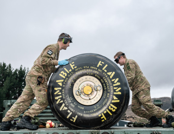 Refuellers roll a deployable container of fuel to the refuelling site