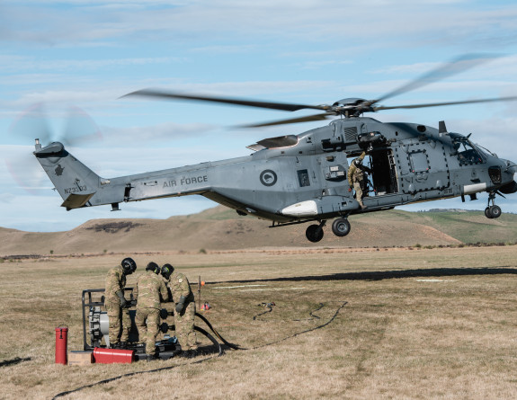 Refuellers get ready to refuel a Royal New Zealand Air Force helicopter which is coming in to land