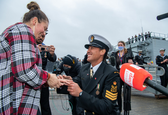 Petty Officer Jacob Biddle went down on one knee on the wharf and proposed to his partner who said ‘yes’ to a chorus of cheers