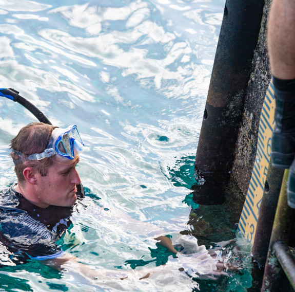 Hydrographers from HMNZS Matataua in the crystal clear waters of the Pacific inspecting the main Sir Robert’s Wharf in Alofi.