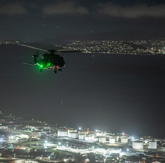 An NH90 helicopter flies over Wellington City