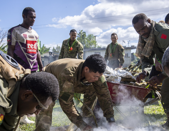 The men helped lay the lovo down and cook other meats on the barbecue.