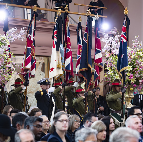 The Queen’s Colours, draped with mourning ribbons, are marched into St Paul’s Cathedral by Colour parties flanked by large bouquets of flowers.