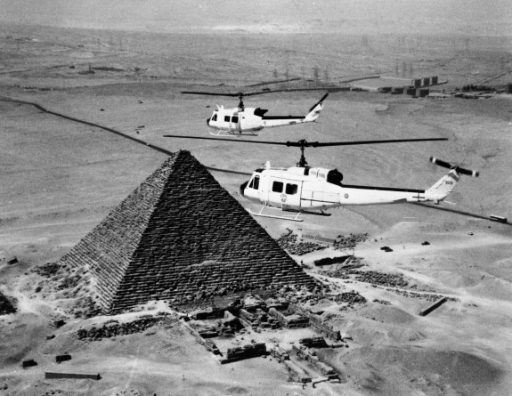 Helicopters flying over pyramid