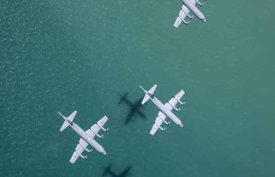 Three P-3K2 Orion flying over the ocean. The image is looking down above the aircraft. 