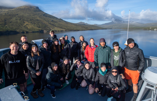 Sir Peter Blake Expedition Members take a photo from HMNZS Canterbury in front of Campbell Island.