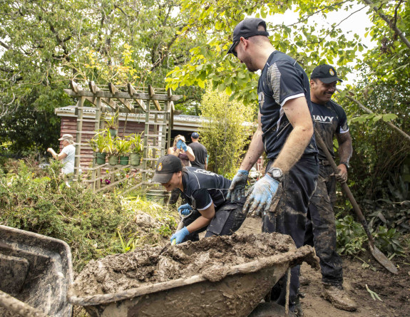 Crewmembers from HMNZS Te Mana work as a clean-up crew in Havelock North.