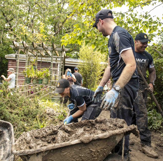 Crewmembers from HMNZS Te Mana work as a clean-up crew in Havelock North.