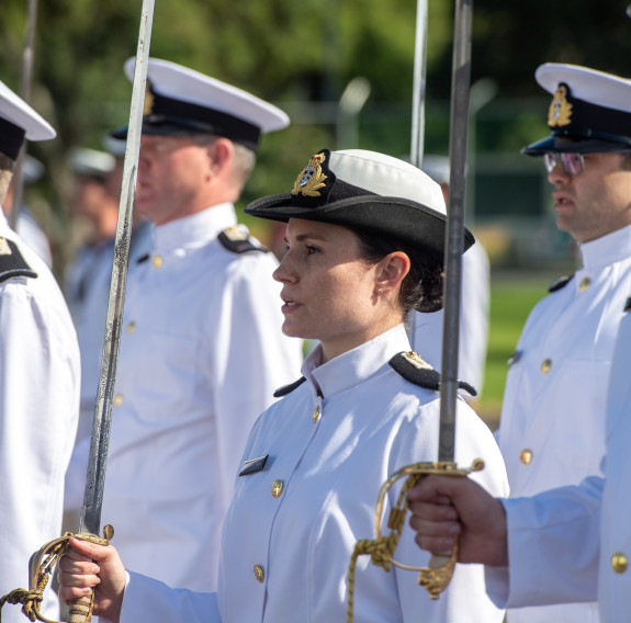 Reservist officers with ceremonial swords stand on the parade ground.