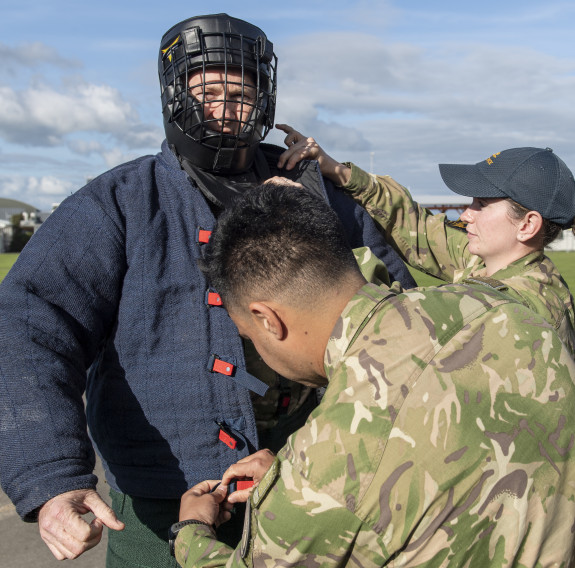 Ohakea’s Base Commander, Group Captain Rob Shearer gets prepared by putting on a navy blue bite suit and padded helmet which has a cage to protect the face.