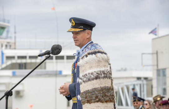 A man in a Royal New Zealand Air Force uniform standing at a microphone.