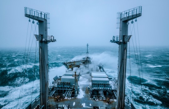 Royal New Zealand Navy's HMNZS Aotearoa sailing through rough seas. The image is dark and moody - no sun.  