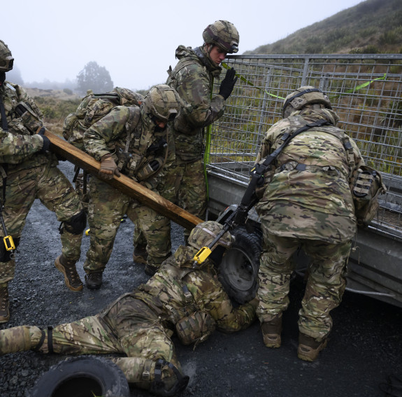 Soldiers work as a team to repair a trailer.