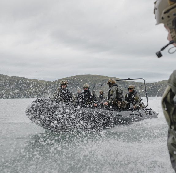 The perspective from one small boat to another as they accelerate through the water and water splashes up between them.