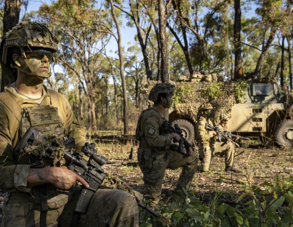 Soldiers in front of a large military vehicle in the Australian bush.