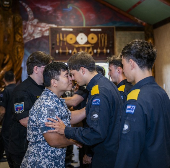Two sailors hongi inside a marae