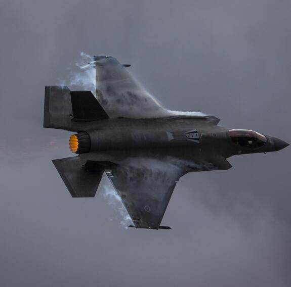 A F-35A Lightning II aircraft in flight - the image looks really moody and you can see how it cuts through cloud as it comes off the wings. 