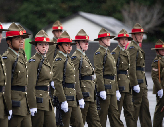 New Zealand Army soldiers stand in a line formation with weapons. 