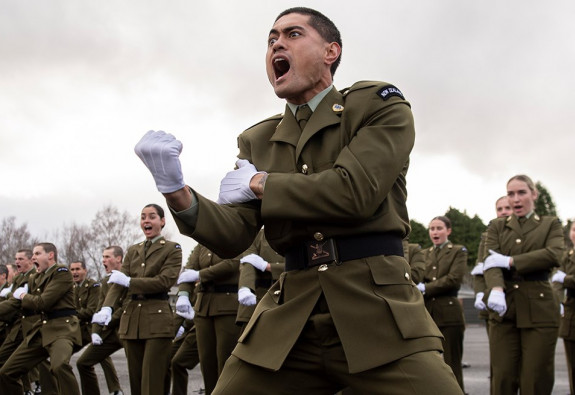 New Zealand Army personnel perform a haka on a cloudy day