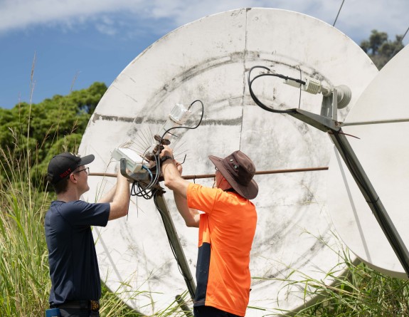 Two technicians make adjustments to monitoring equipment on Raoul Island.