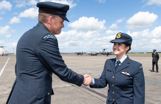 Pilot Officer Ali McKain in full dress uniform graduates Wings Course, on the flightline at Base Ohakea.