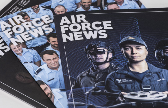 Three editions of Air Force News stacked a table