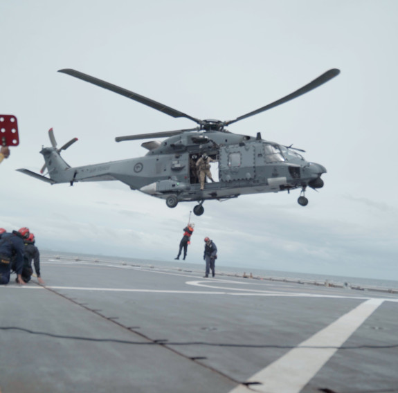 NH-90 and flight deck crew on board HMNZS Canterbury practise winching a person off the flight deck en-route to Fiji.