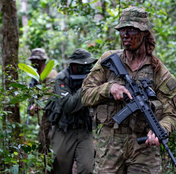 New Zealand Army and Republic of Fiji Military Forces personnel navigate the jungle in full camouflage.