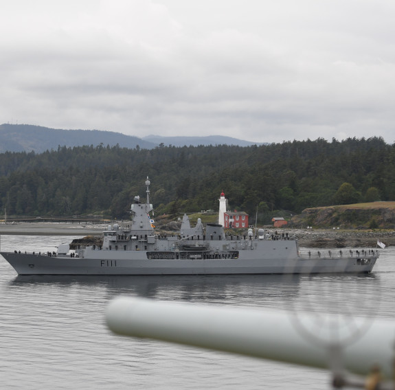 HMNZS Te Mana departing Esquimalt Harbour in Canada on an overcast day.