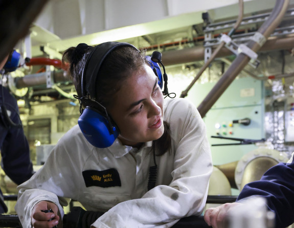 Sub Lieutenant Emily Aull working on components while talking to a colleague.