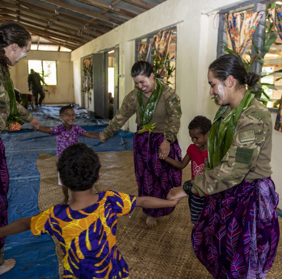 Officer Cadet Jasmine Hill dances with children from the local Nausori Village, whose land they used to undertake their exercise