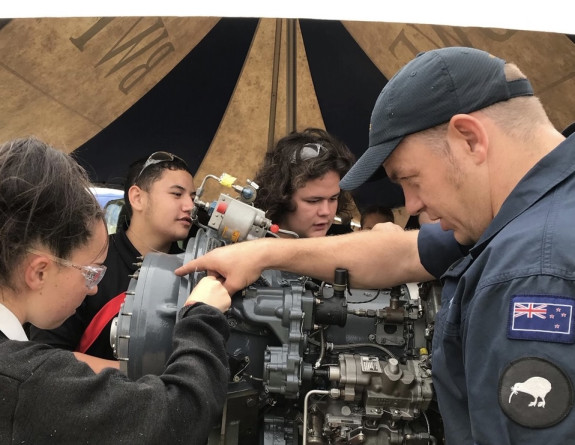 A Royal New Zealand Air Force Airmen assists local school students in the Wairarapa with an engine at Wings Over Wairarapa 2021