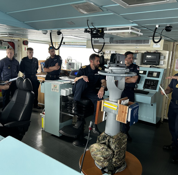A brief is held on the bridge of HMS Spey, personnel are listening to the plan as navigational equipment is throughout the area. 