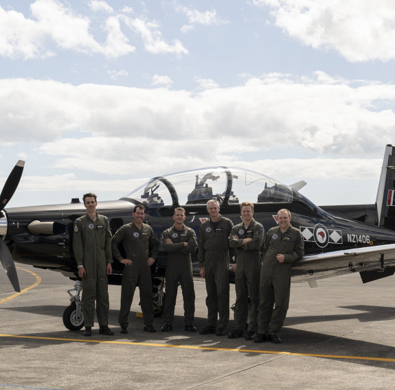 Black Falcons 2023 team in uniform in front of a RNZAF Texan Aircraft