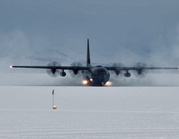 A Royal New Zealand Air Force C-130J Hercules at Phoenix Airfield, Antarctica during a medical evacuation mission. There is ice all around the aircraft. 