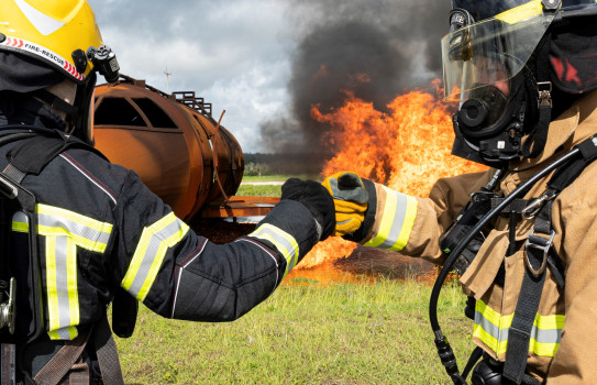 RNZAF and USAF firefighters fist bump prior to conducting a joint live-fire training exercise during Mobility Guardian 23 (Staff Sergeant Malissa Lott, USAF)