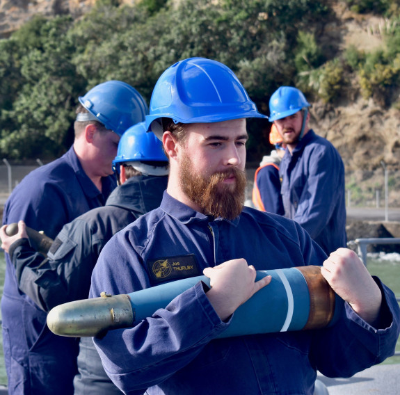 AET Joe Thurlby cradles a five-inch shell during Te Mana’s ammunitioning at Kauri Point.