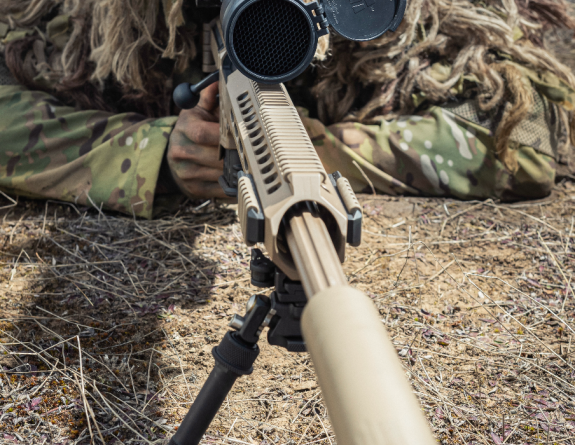 A close up shot of a New Zealand Army soldier and a MRAD Sniper Rifle