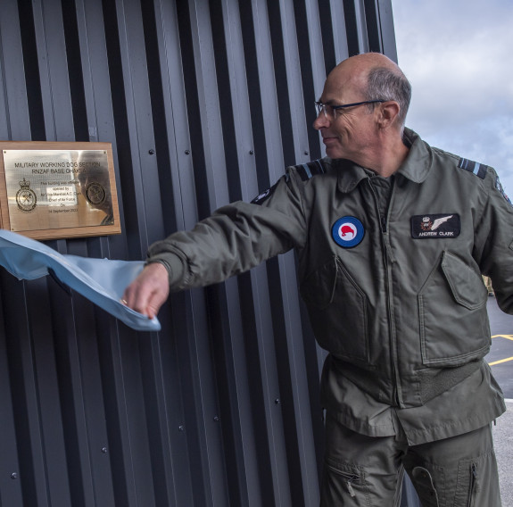 Chief of Air Force Air Vice Marshal Andrew Clark smiles as pulls some fabric off the opening plaque on the new Military Working Dog facility. 