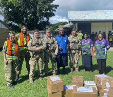 Corporal Janice Bond, left, Leading Aircraftman Jared Fairburn-Smith, Corporal Jarrod Milligan, Sergeant Tom Hanson, and Flight Lieutenant Hamish Park from No. 3 Squadron pose with Nagalevu Ravuama of the Western Commissioner’s office and teachers at Ratu