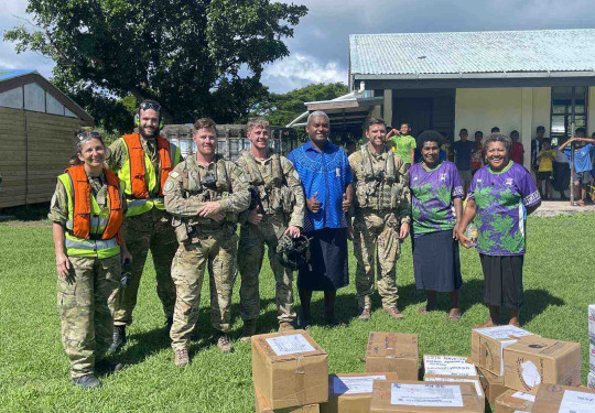 Corporal Janice Bond, left, Leading Aircraftman Jared Fairburn-Smith, Corporal Jarrod Milligan, Sergeant Tom Hanson, and Flight Lieutenant Hamish Park from No. 3 Squadron pose with Nagalevu Ravuama of the Western Commissioner’s office and teachers at Ratu