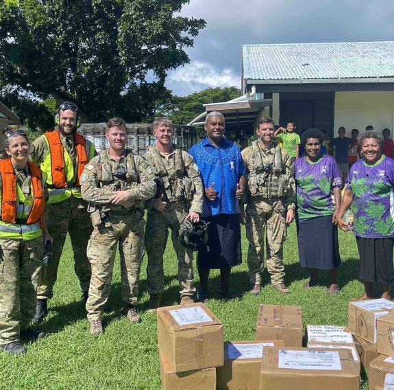 Corporal Janice Bond, left, Leading Aircraftman Jared Fairburn-Smith, Corporal Jarrod Milligan, Sergeant Tom Hanson, and Flight Lieutenant Hamish Park from No. 3 Squadron pose with Nagalevu Ravuama of the Western Commissioner’s office and teachers at Ratu