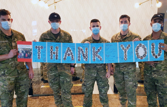 Soldiers hold thank you sign in MIQ
