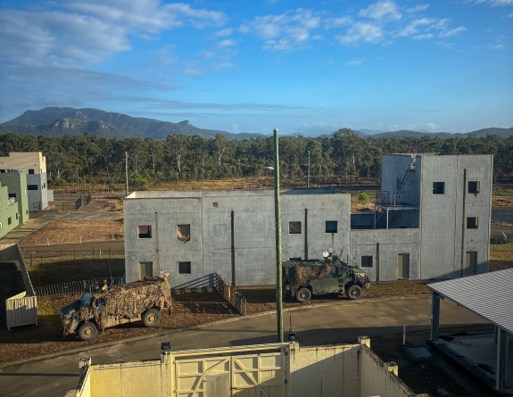 Light Armoured Vehicles and infantry conduct an assault onto the Urban Operations Training Facility at Raspberry Creek in the Shoalwater Bay Training Area in Queensland.