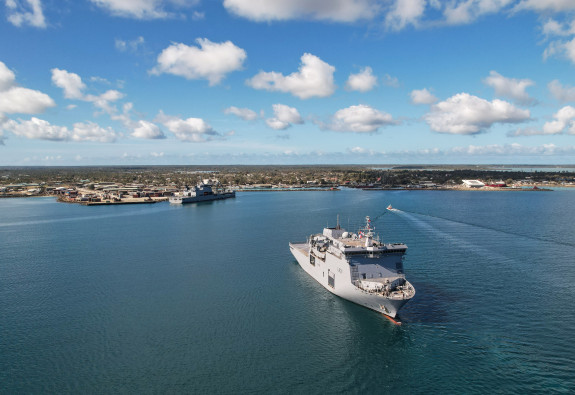 Tonga relief efforts: On a sunny day with a blue sea and sky with a few clouds, HMNZS Canterbury in the foreground while HMNZS Aotearoa is docked at Nuku’alofa, Tonga