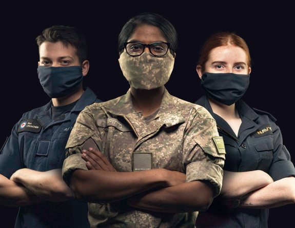 An airmen, soldier, and sailor standing together wearing masks to protect themselves from COVID-19