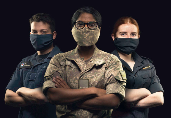 An airmen, soldier, and sailor standing together wearing masks to protect themselves from COVID-19