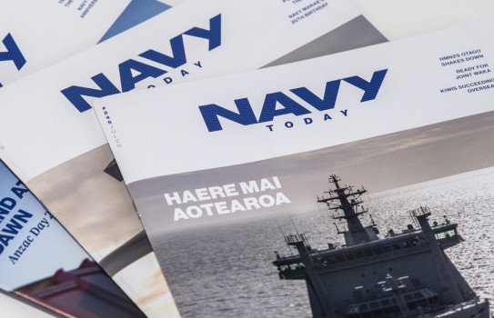 Three editions of Navy Today stacked a table 
