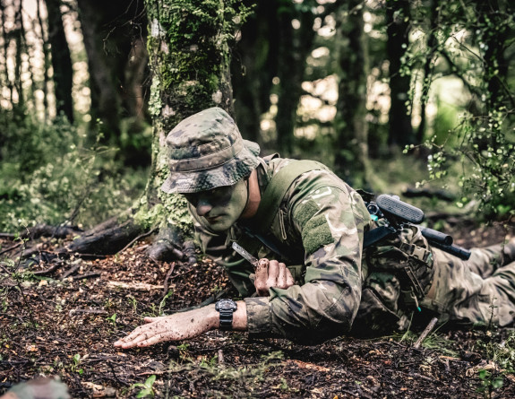 A soldier trains in mine clearance in the field phase during Reserve Force Infantry Corps Training - army crawls on the forest floor