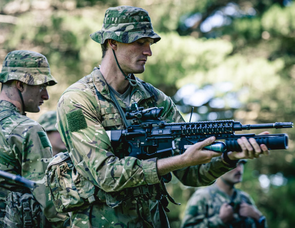 Asoldier practices using the 40mm grenade launcher during dry drills with other platoon members